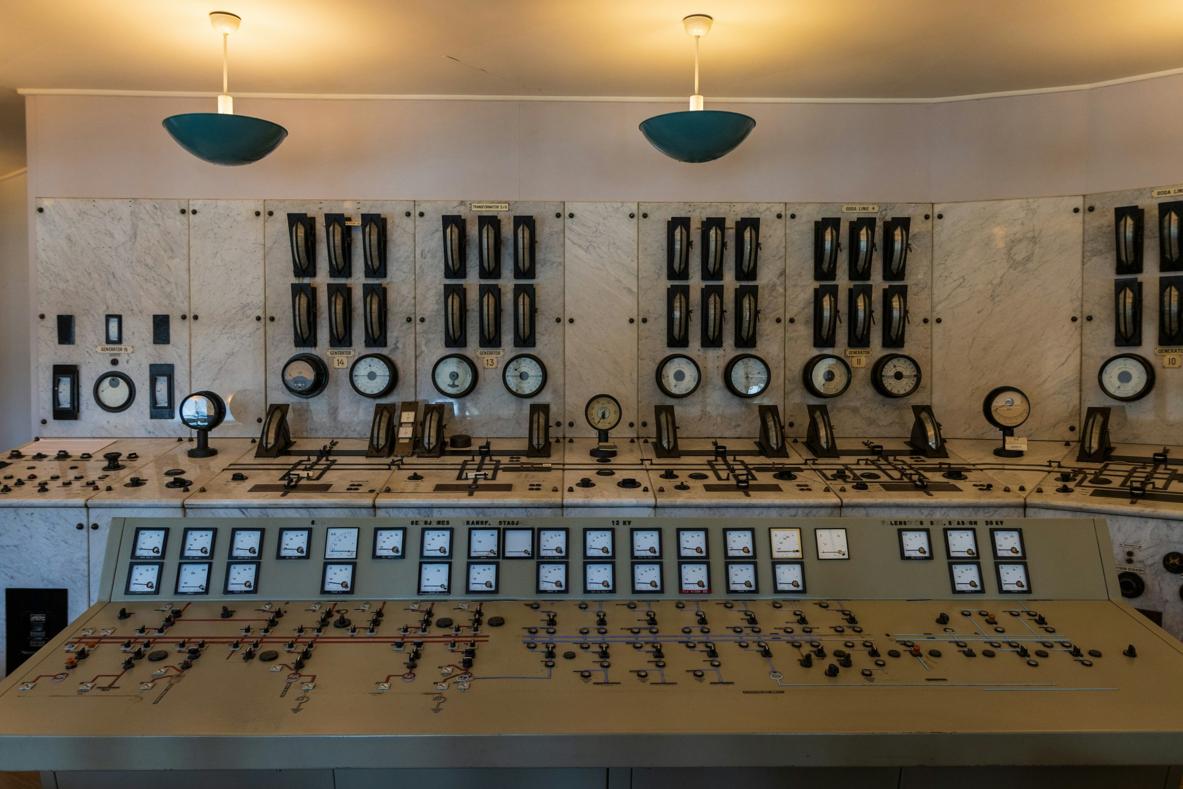 An industrial control room with banks of operator screens.