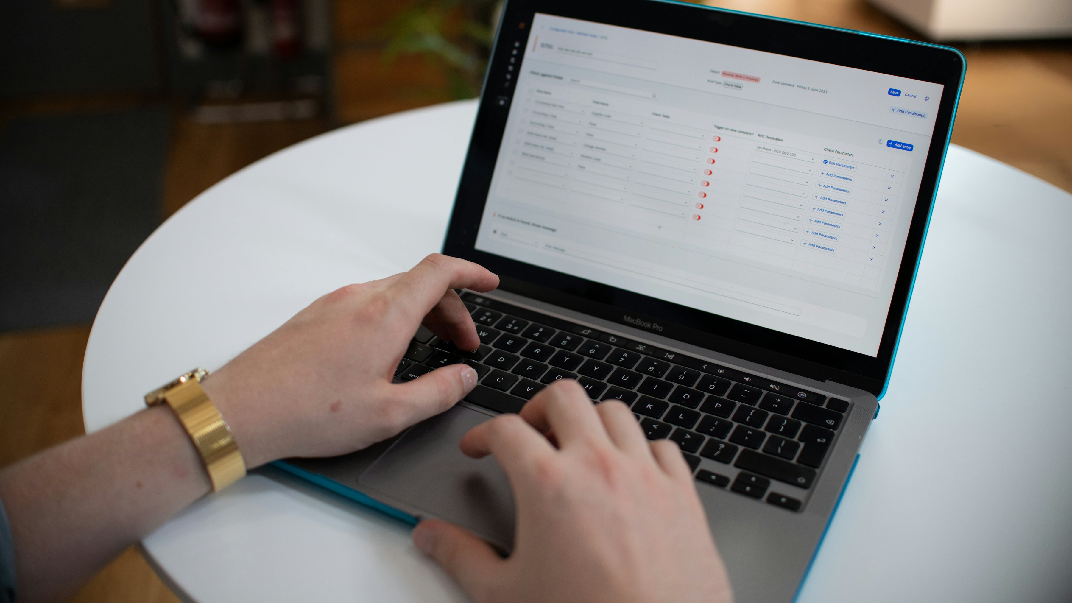 Hands typing on a laptop showing a spreadsheet