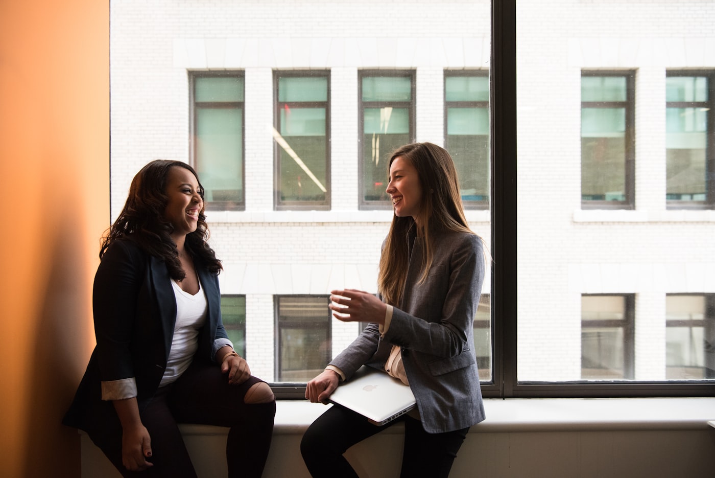 Two colleagues talking by an office window