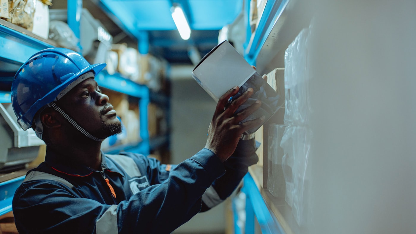 Warehouse worker in a hard hat checking paperwork